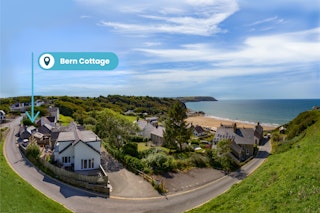 View of village with a sign above Bern Cottage showing the location