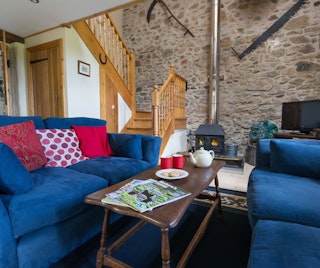Lounge area with two sofas, coffee table and log burner