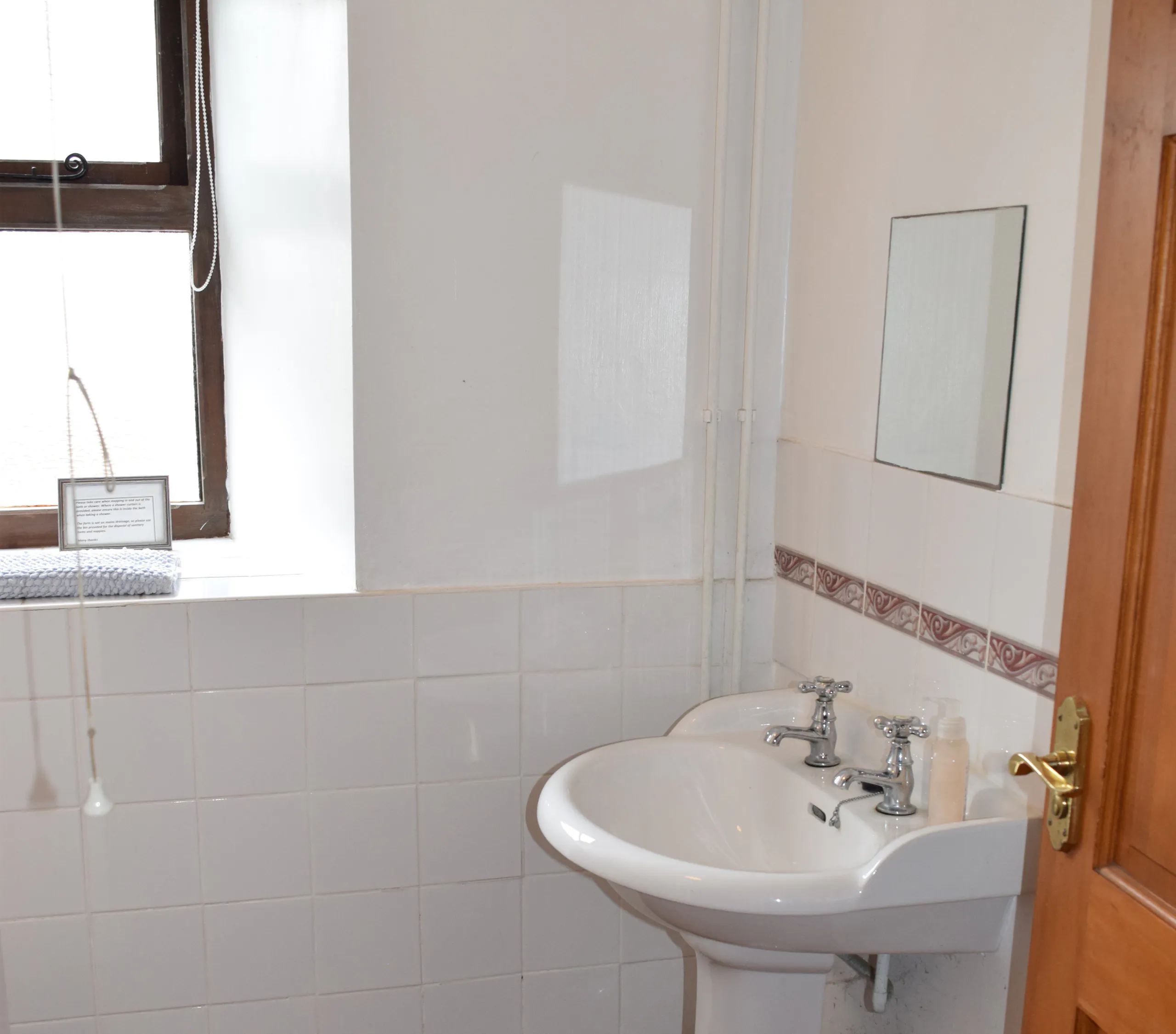 Ground floor shower room, wash basin with mirror above and window