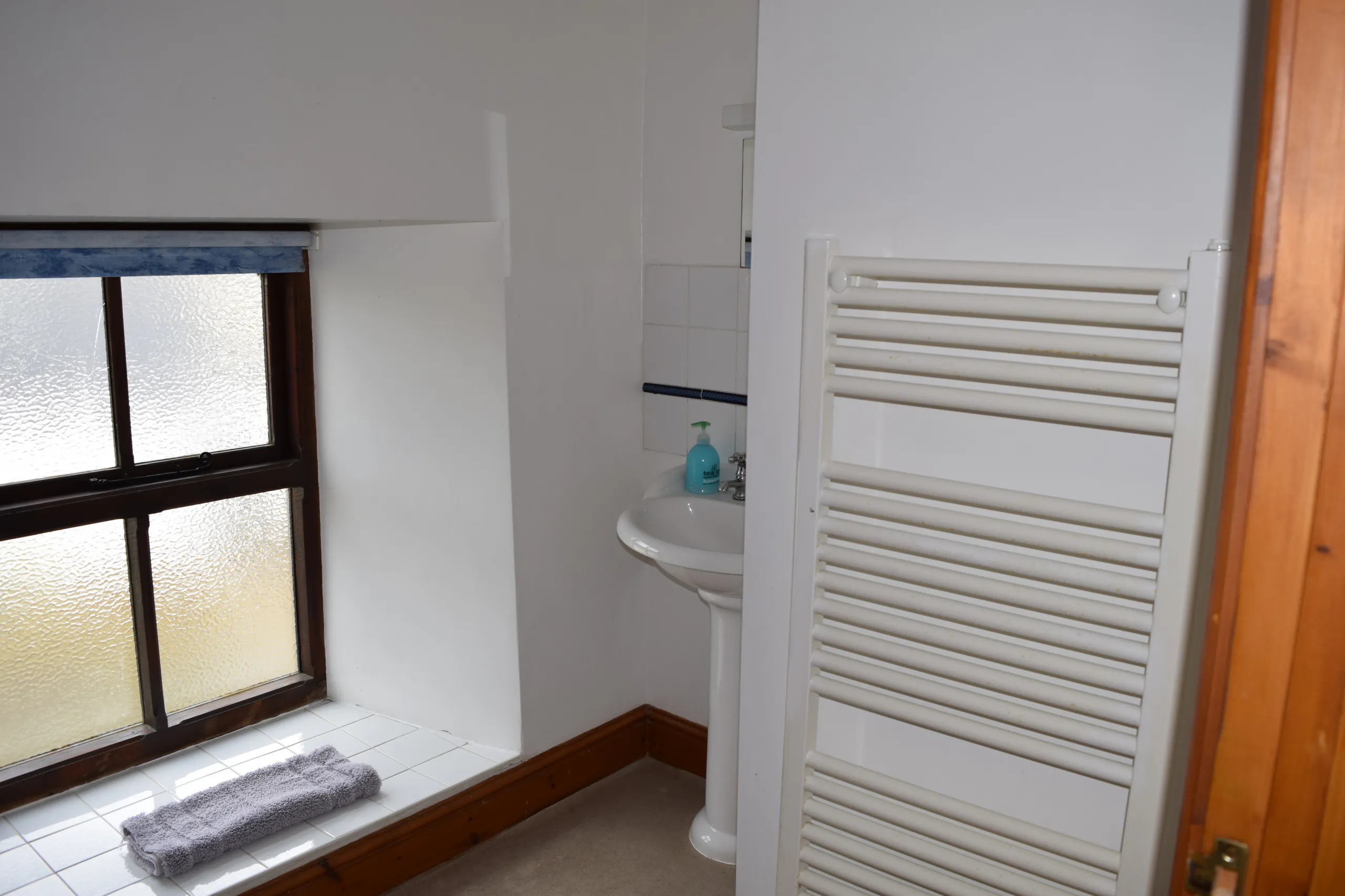 First floor main bathroom: hand basin with mirror above and heated towel rail