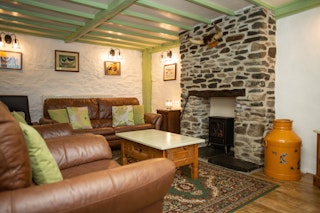Lounge with leather sofa and two arm chairs and log burner