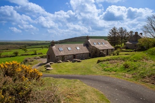 View of Cnwc y Bran cottage, the entrance track and surrounding countryside