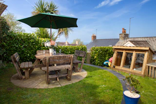 Garden with wooden table and chairs and parasol