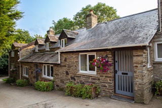 Freesia Cottage with hanging basket and potted plants outside