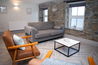 Living room with sofa, armchairs, coffee table, sea views from the windows