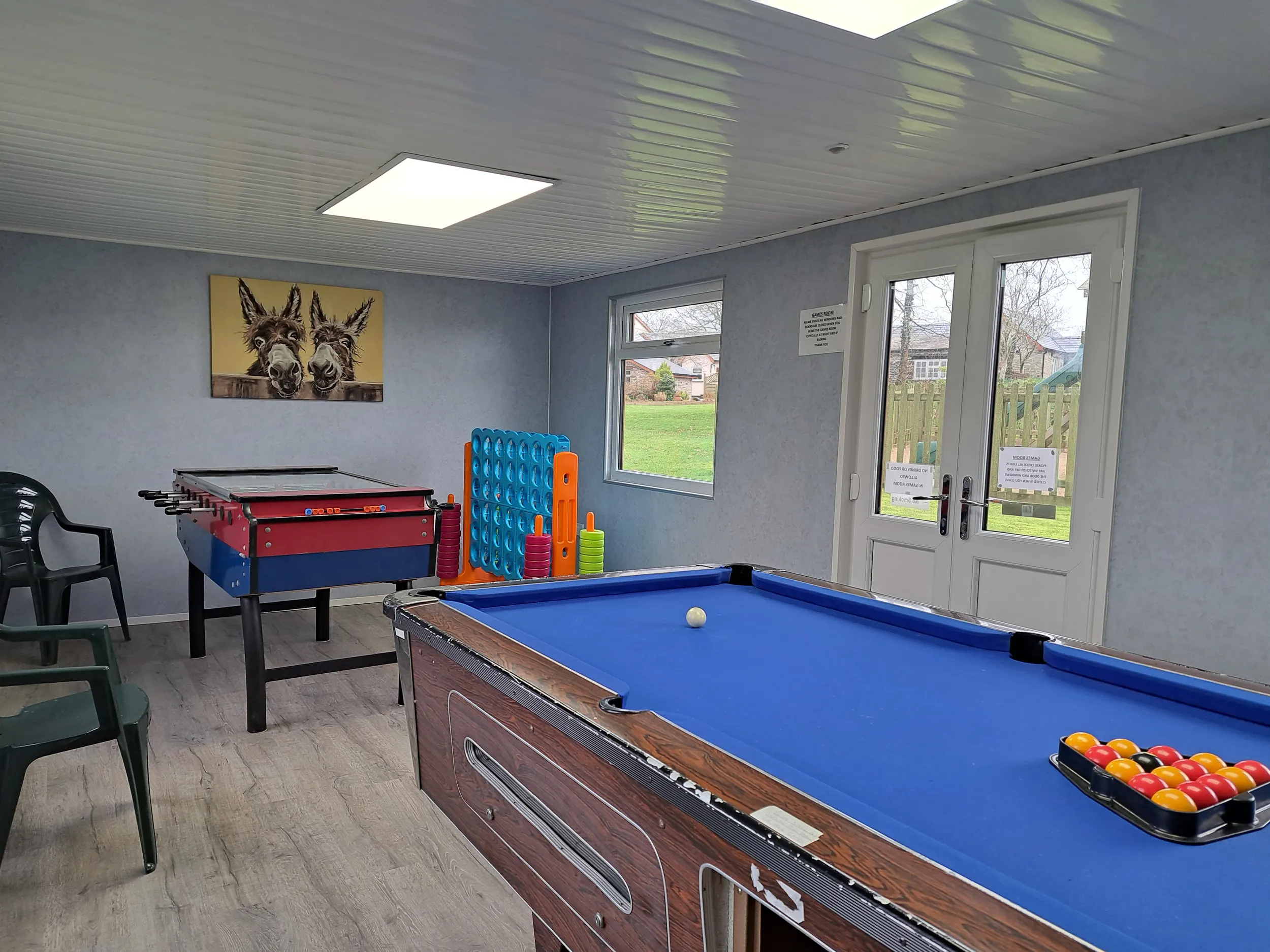 Games room with pool table, table football. Connect 4, chairs and and patio doors