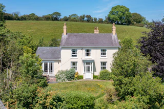 Farmhouse with mature gardens, surrounded by fields