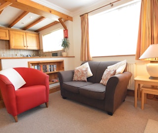Light open plan living space with sitting area and kitchen at Brynhelyg Cottage