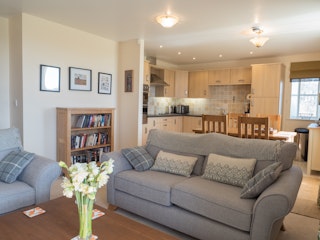 Bright living room in St Brides View with sofas, dining table, chairs and kitchen