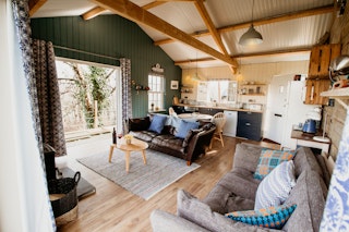 Open plan living area with kitchen, dining table and chairs, sofas, doors to veranda