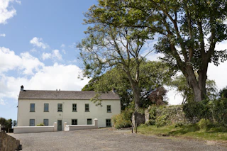 Outside view of Great Nash House, lawn, low walls, front door