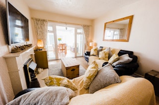 Ty Merlyn sitting room with patio doors leading to conservatory