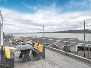 Balcony at ther front with bench and chairs overlooking the bay