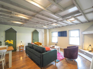 Sandy Cove sitting room with wooden floors and beamed ceiling