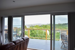 Large doors leading from sitting room to balcony with views of the harbour