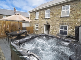 Hot tub  with parasol, patio table, and 6 chairs