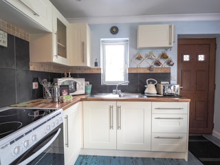 White wall and base cupboards. Electric cooker